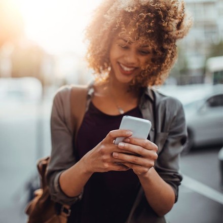 lady-walking-street-holding-smartphone